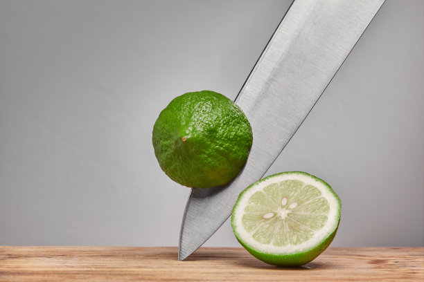 在刀上的木砧板上切青柠图片下载