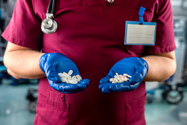 身穿红色制服的医生在病房里拿着药片图片下载