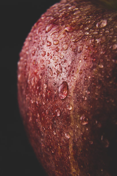 红色美味的苹果微距照片与水滴，黑暗穆迪的照片。抽象的水果背景图片下载