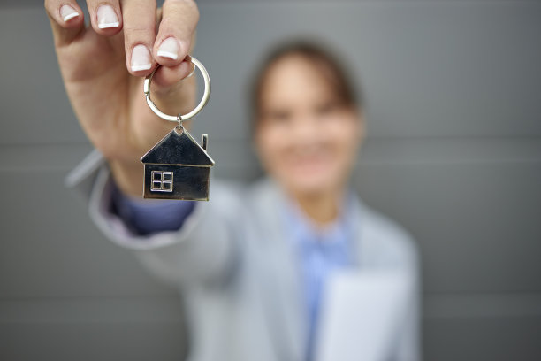 模糊肖像的年轻女房地产经纪人手里拿着钥匙图片下载
