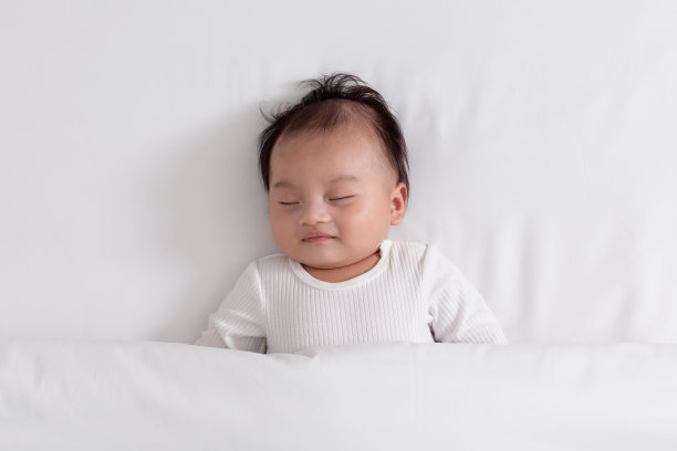 快乐的亚洲新生儿躺在白色的床上睡觉舒适和安全。可爱的亚洲新生儿睡觉和午睡在温暖的地方深度睡眠和新鲜的呼吸。新生儿睡眠的概念。俯视图图片下载