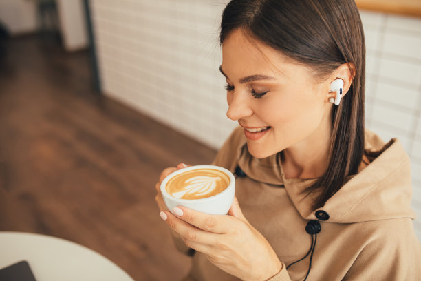 年轻女子坐在舒适的咖啡馆里喝着卡布奇诺。图片下载