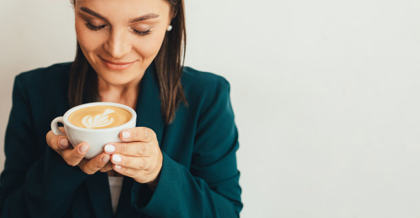 年轻女子坐在舒适的咖啡馆里喝着卡布奇诺。图片下载