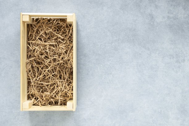 顶部的看法，木制的生态礼物充满装饰撕碎白色纸在灰色背景拷贝空间平lay图片下载