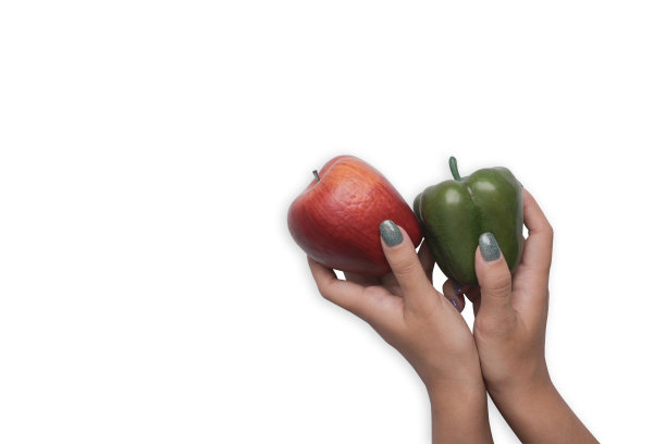 女人的手拿着甜辣椒和苹果孤立在白色背景与拷贝空间。图片下载
