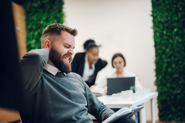 坐在办公桌前颈部疼痛的商人图片下载