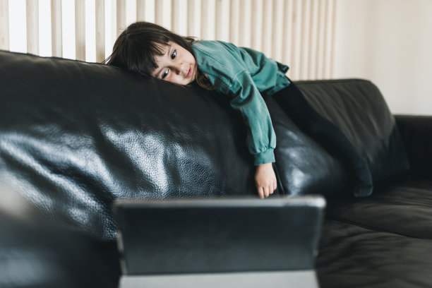 无聊的孩子在平板电脑上看动画片图片下载