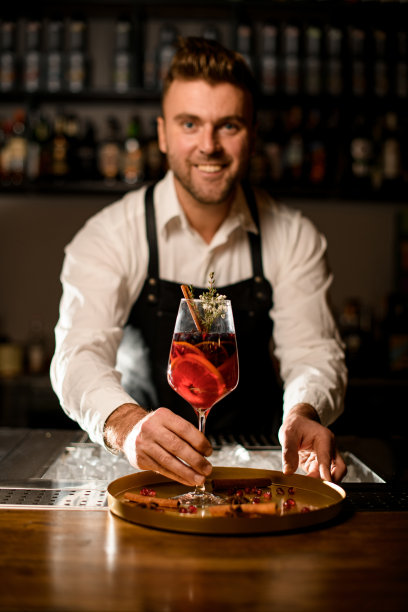 男调酒师的手轻轻握住盛酒的高脚杯图片下载