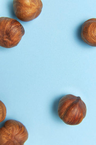 创新食品布局。蓝色背景上的榛子顶部视图拷贝空间。食品的概念，健康营养，坚果，健康脂肪。榛子平。核桃的模式。有机健康素食小吃特写图片下载