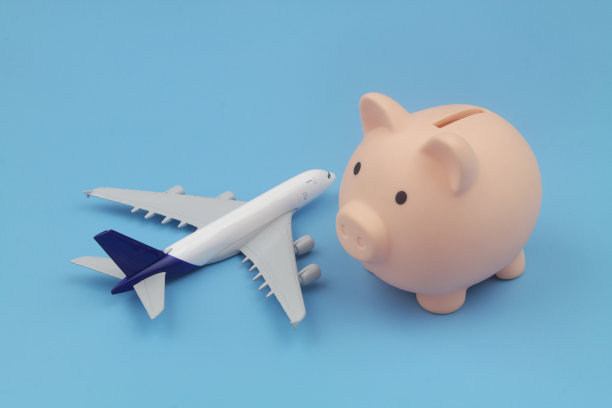 蓝色背景上的飞机模型、储蓄罐和计算器图片下载