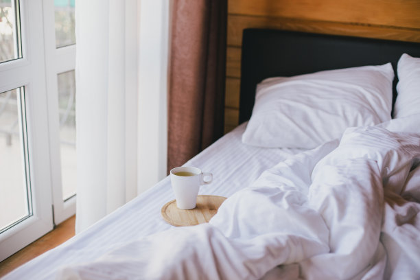 在舒适的木屋里，躺在床上喝一杯绿茶。图片下载