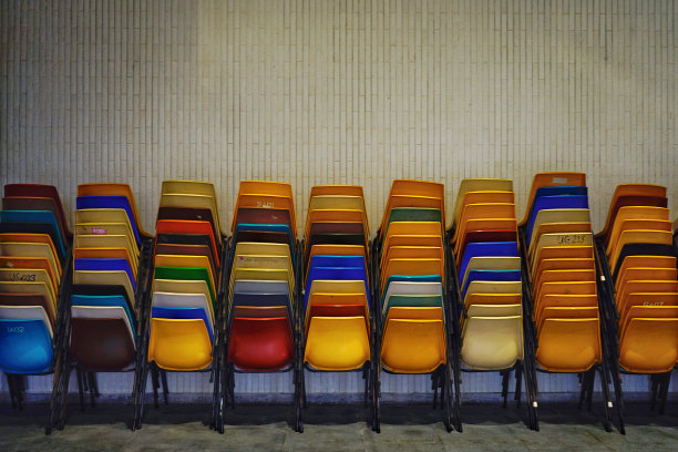 靠墙的彩色椅子堆。图片下载
