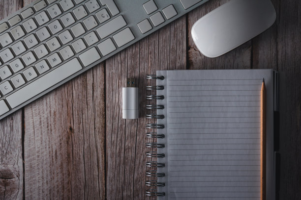 木制背景上的电脑键盘、鼠标、笔记本和USB闪存盘的工作区图片下载