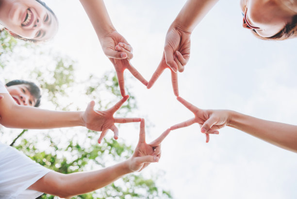 近距离的人们志愿者团队合作，把手指放在星星形状，手在一起，成堆的手，团结和团队在世界环境日。图片下载