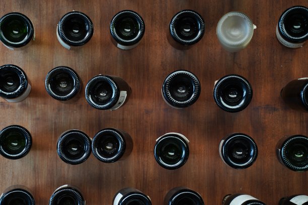 许多酒瓶底部的酒刺在木墙上，为餐厅装修室内设计的墙壁背景。图片下载