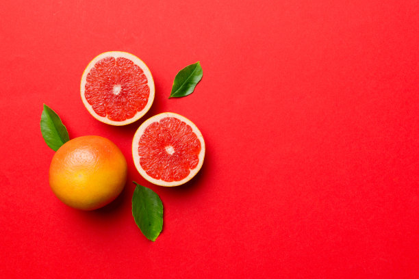 鲜果柚子与多汁柚子切片彩色背景。前视图。副本的空间。创造性的夏天的概念。一半柑橘在最小的平铺复制空间图片下载