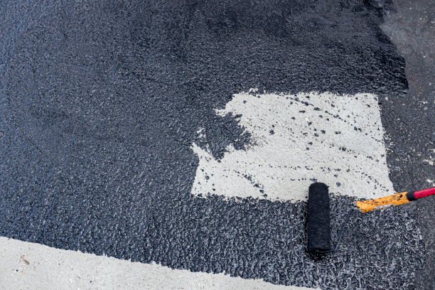 工人用滚筒进行防水处理的第一阶段，第一层基础层图片下载