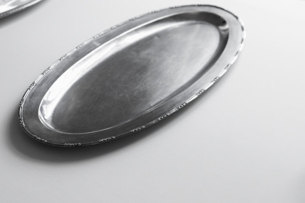 白色桌布上放着一个空银盘图片下载