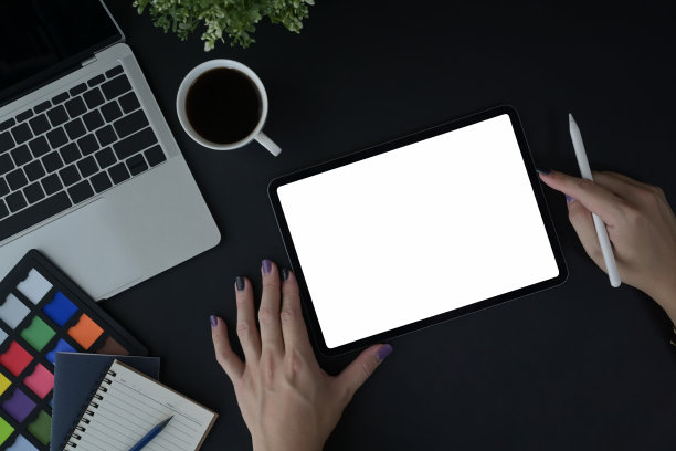在创意工作场所使用数字平板电脑的女性设计师的手。图片下载