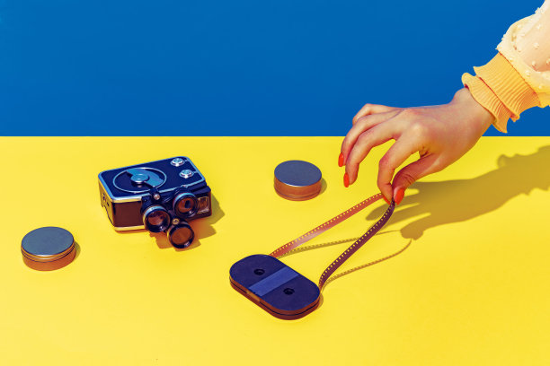 波普艺术摄影。彩色图像的复古照片相机在明亮的黄色桌布上孤立的蓝色背景图片下载