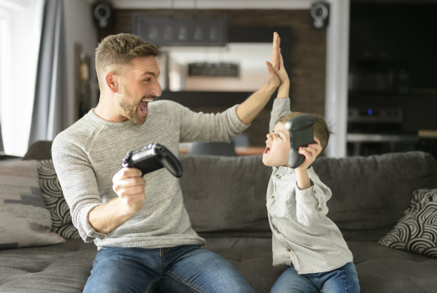 父亲或教父在客厅玩游戏在家里图片下载