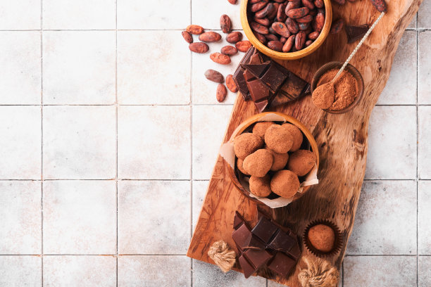 巧克力松露与可可粉在木制盘子在旧裂瓦桌子背景。美味甜美的巧克力松露糖果。情人节和母亲节的概念与拷贝空间。前视图。图片下载