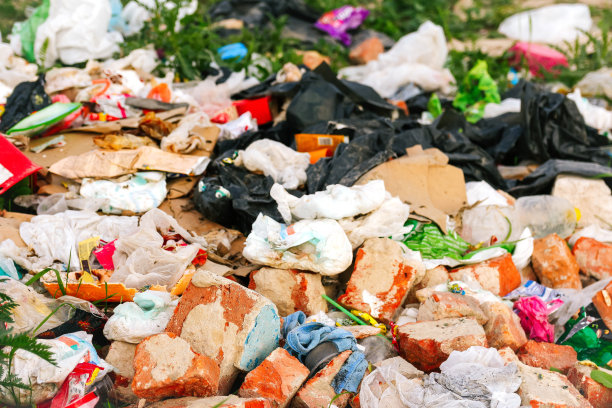 散焦巨大的垃圾填埋场。生态学的概念。大型垃圾堆在大自然绿草的背景下，全球变暖。特写镜头。污染。抽象的背景。的焦点图片下载