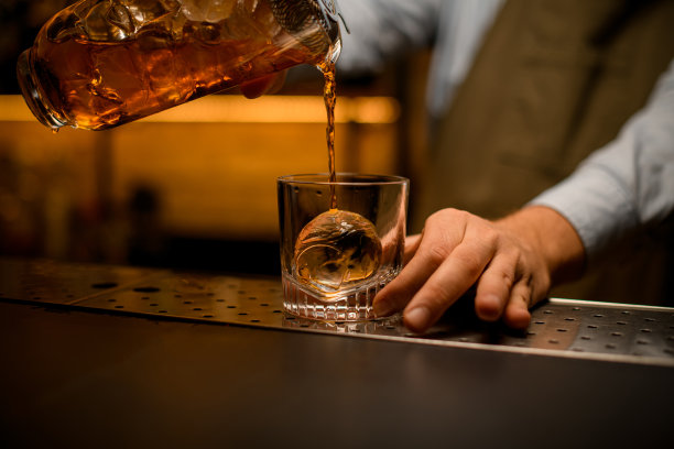 一杯饮料倒进一块冰的玻璃图片下载