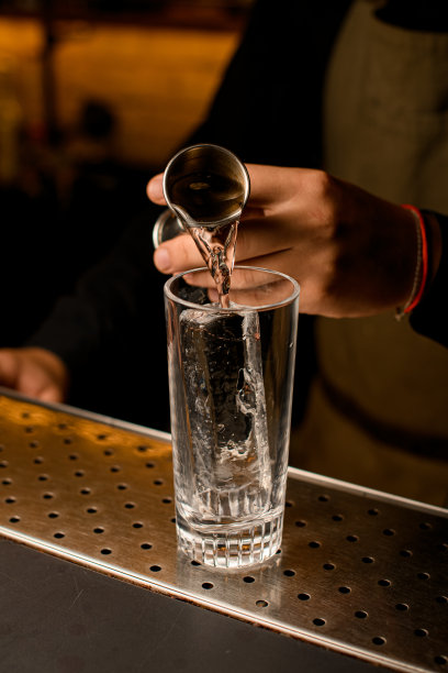 特写一杯冰，其中倒饮料从jigger图片下载