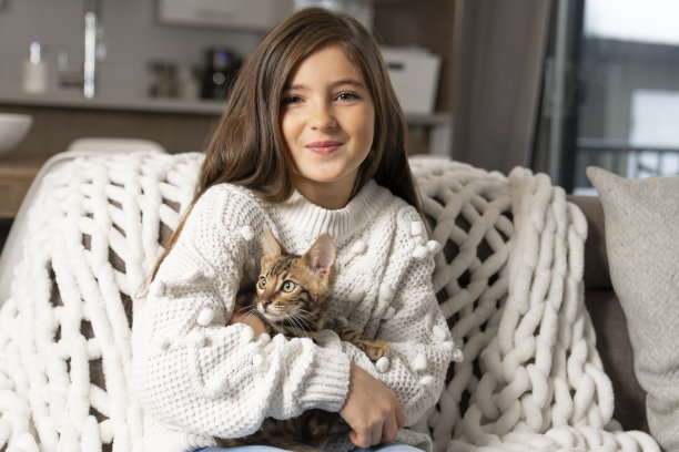 孟加拉猫在客厅的沙发上抱着孩子图片下载