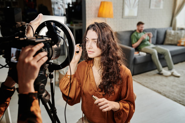 年轻漂亮的女人在画室里涂睫毛膏图片下载