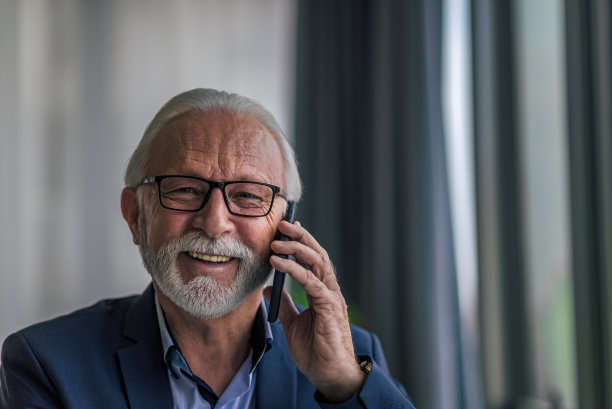 特写肖像微笑高级专业人员在办公室打电话图片下载