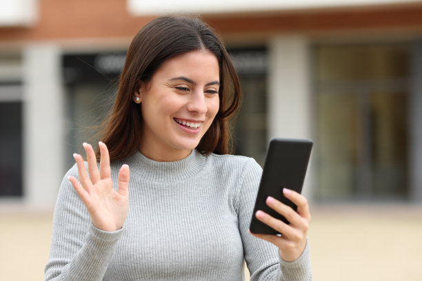 快乐的青少年问候在视频电话在街上图片下载