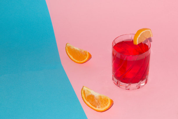 草莓汁在柔和的蓝粉色背景上，周围装饰片橙和柠檬，创意夏季概念图片下载