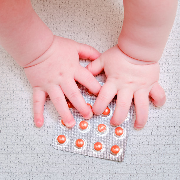 婴儿手和药品片剂一个包，特写。孩子们的手指和白色背景上的一个物体图片下载