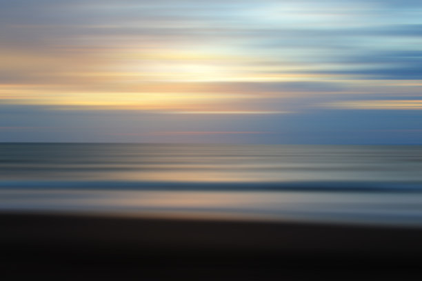 自然的蓝色背景与日落光和平滑的波浪运动在海滩上。图片下载