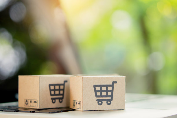 网上购物。笔记本电脑键盘上带有购物车标志的纸板箱。网上购物服务。提供送货上门。本空间图片下载