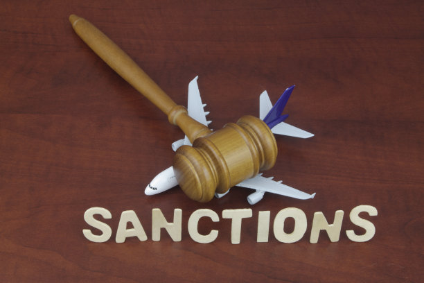 木制法槌与飞机模型，背景为“制裁”字样图片下载