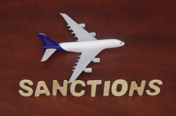 木质背景上的飞机模型和制裁字样图片下载