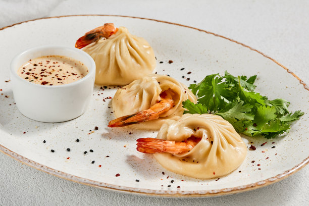 亚洲风味蒸饺虾白色混凝土背景。陶瓷盘酱虾仁点心。虾馄饨，简约风格。亚洲海鲜饺子。图片下载