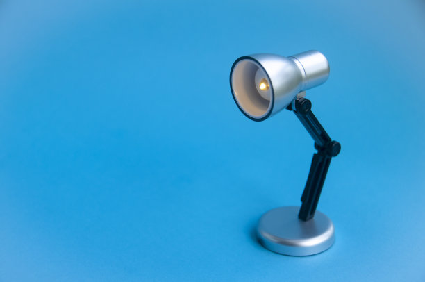 特写的银色和黑色的小灯在蓝色的封面背景。复制空间概念图片下载