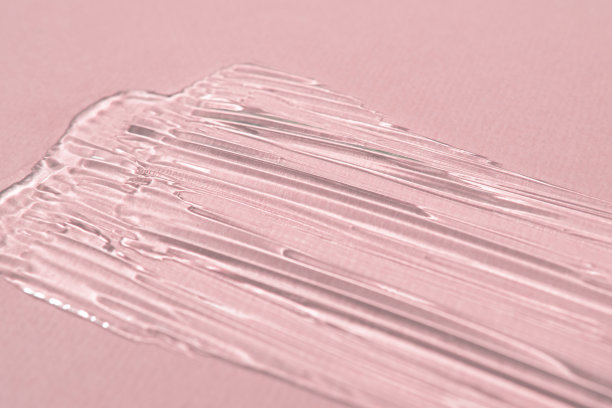 样品液体透明化妆品身体凝胶彩色背景。质地洁面和护肤产品，透明质酸保湿，涂抹面膜，芦荟化妆水对粉红色。图片下载