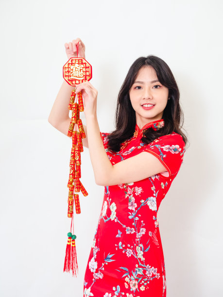 年轻的亚洲妇女穿着传统的旗袍旗袍举行中国节日对联庆祝新年与文字的意思好运在白色的背景。图片下载