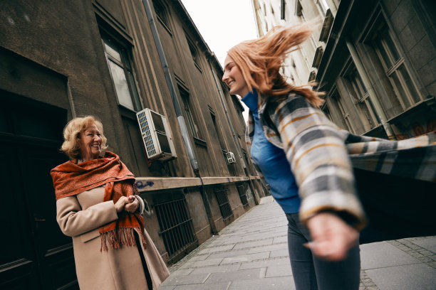 一个顽皮的孙女在街上为她的祖母旋转跳舞。图片下载