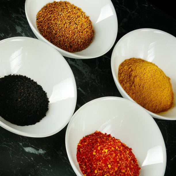 一套香料装在白色杯子里，放在黑色杯子里。图片下载