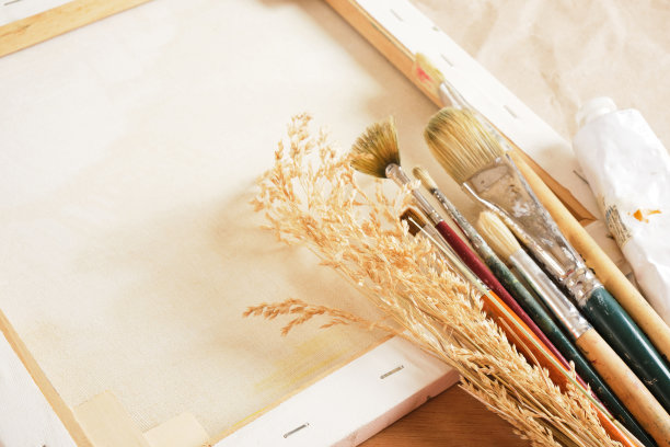 画笔，管状颜料，木制调色板，担架上的画布，桌子上的纸和亚麻布，一个艺术家的工作室图片下载