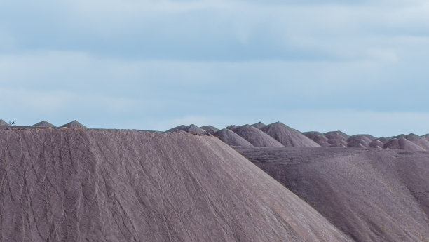 在多云的天空背景下开采钾矿时的空矿山。把一块空石头运到垃圾场。图片下载