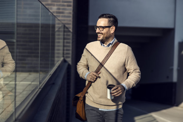 一个快乐的商人喝着早上的咖啡去上班。图片下载