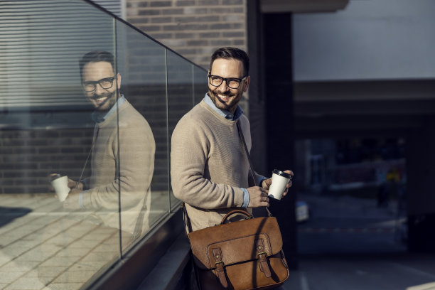 一个愉快、潇洒、随意的男人靠在杯子上喝着咖啡。图片下载