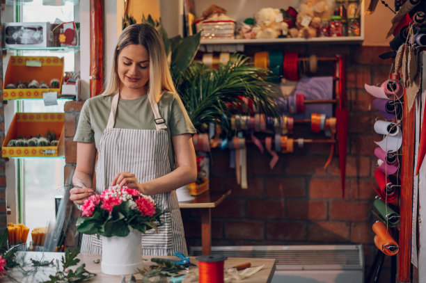在一个圆盒子里创造插花的花匠女人图片下载